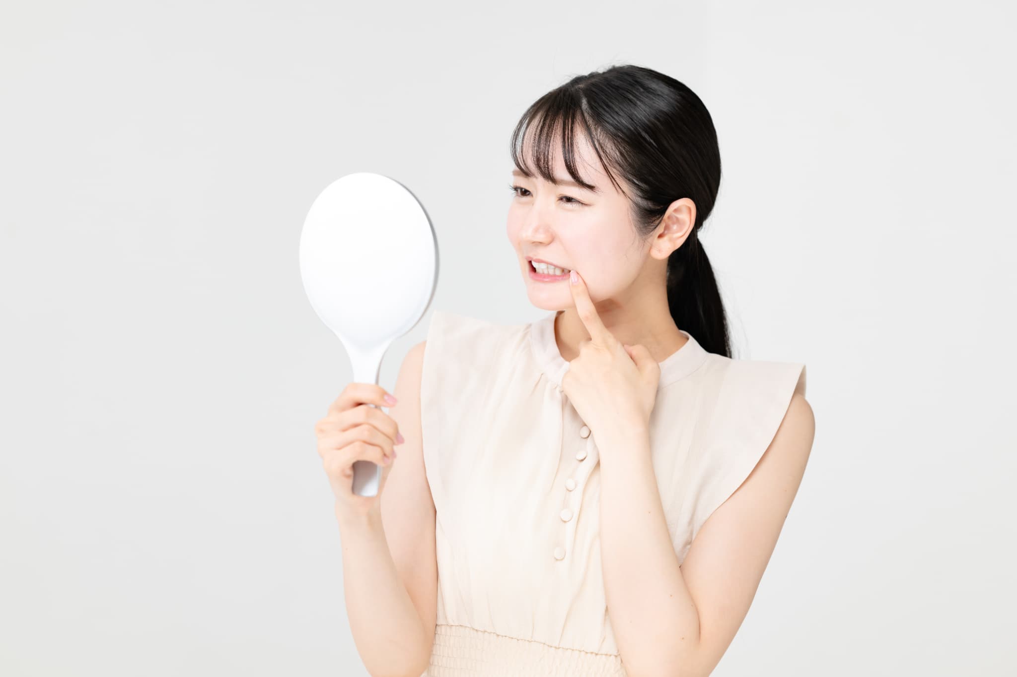 虫歯の進行が気になって鏡を見る女性