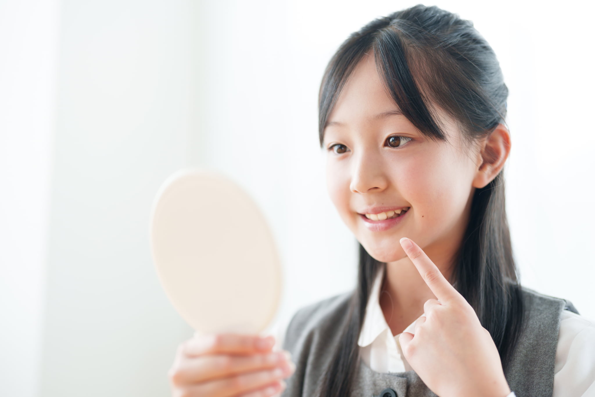 虫歯を予防し鏡をチェックする子ども
