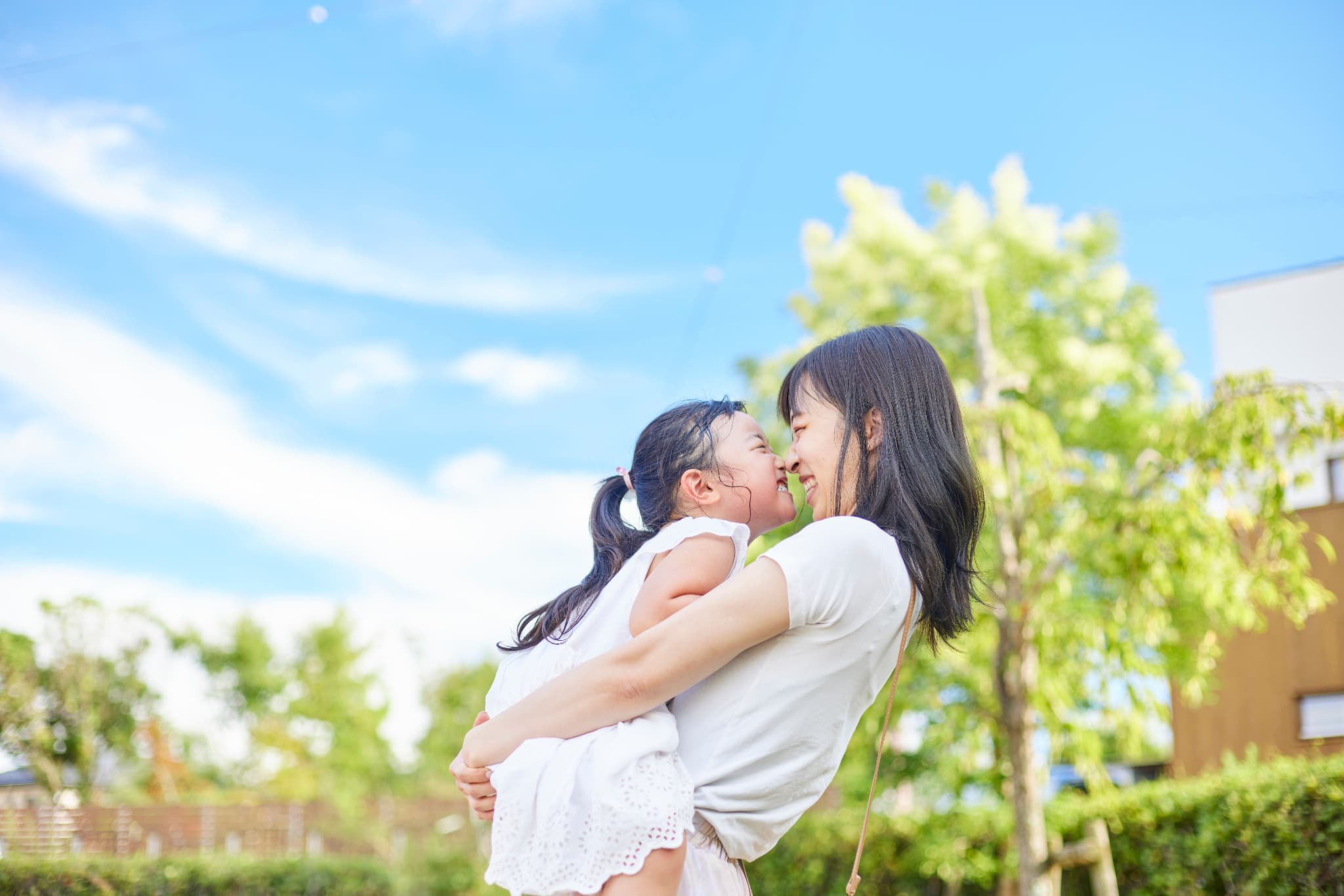 子どもを抱き上げる母親と笑顔の子ども
