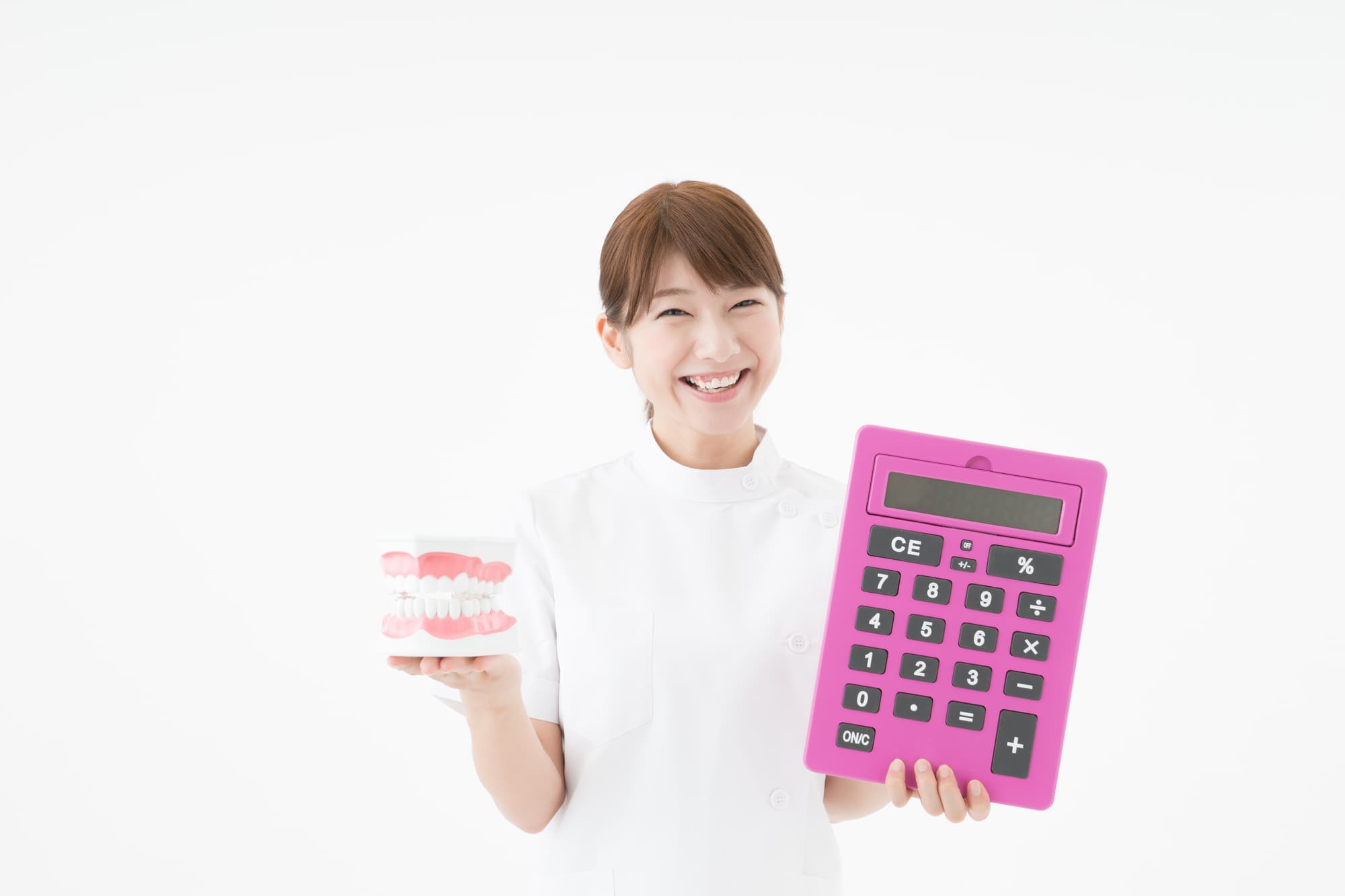歯の模型と大きな電卓を持って微笑む歯科衛生士