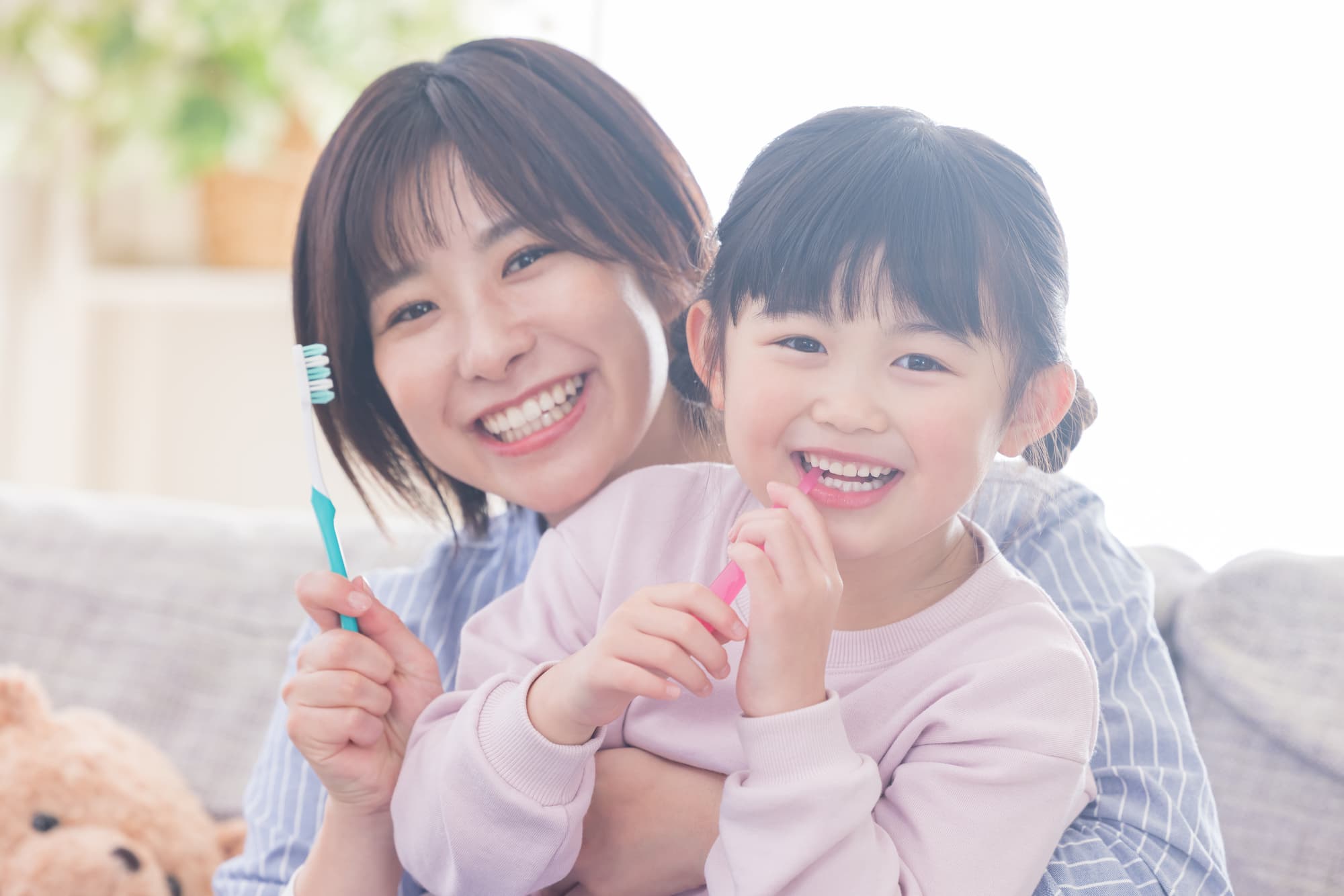 虫歯を予防するために歯磨きをする親子