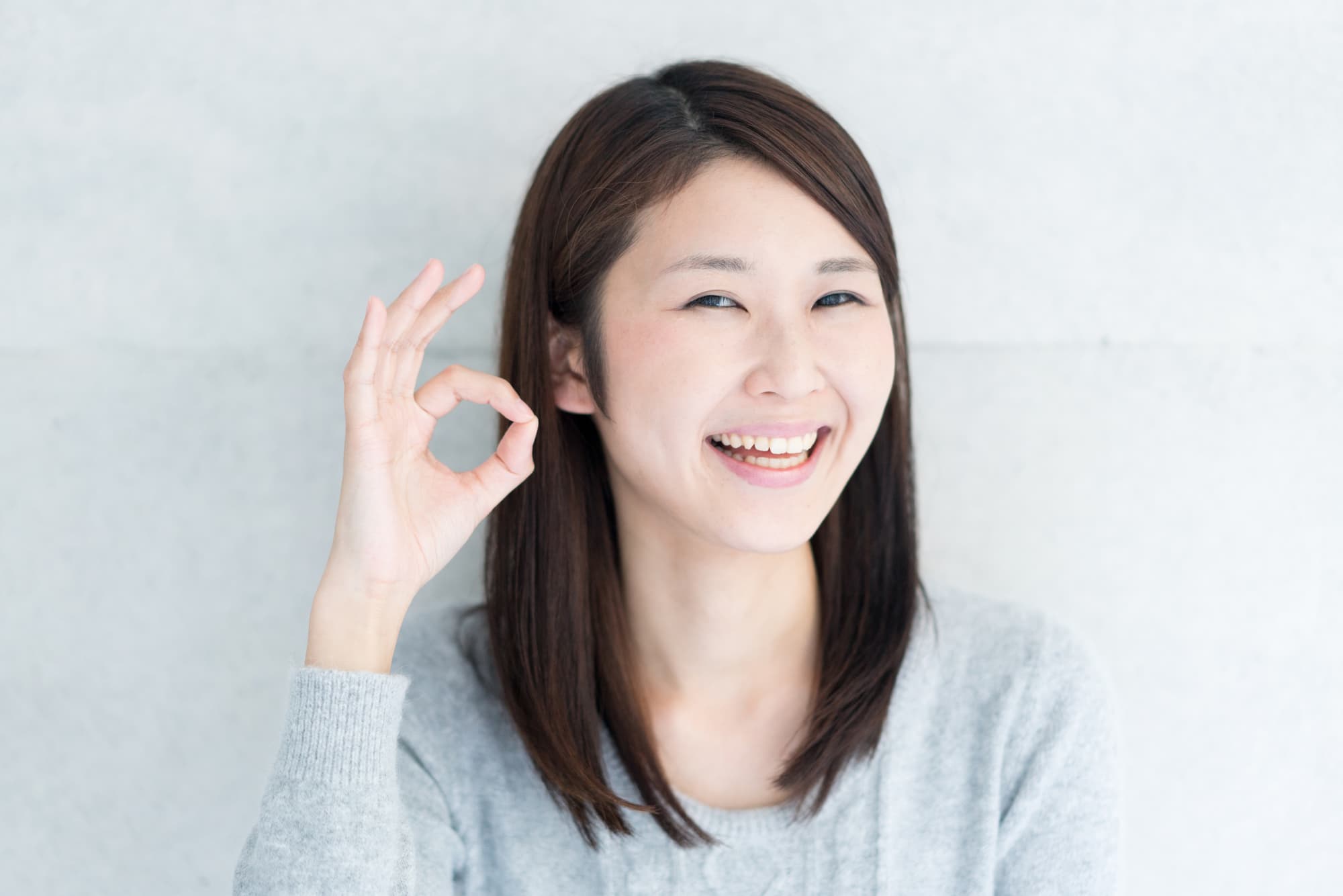 OKサインを指で作る女性