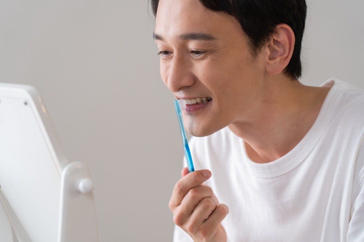 歯周病を予防するために歯磨きをしている男性